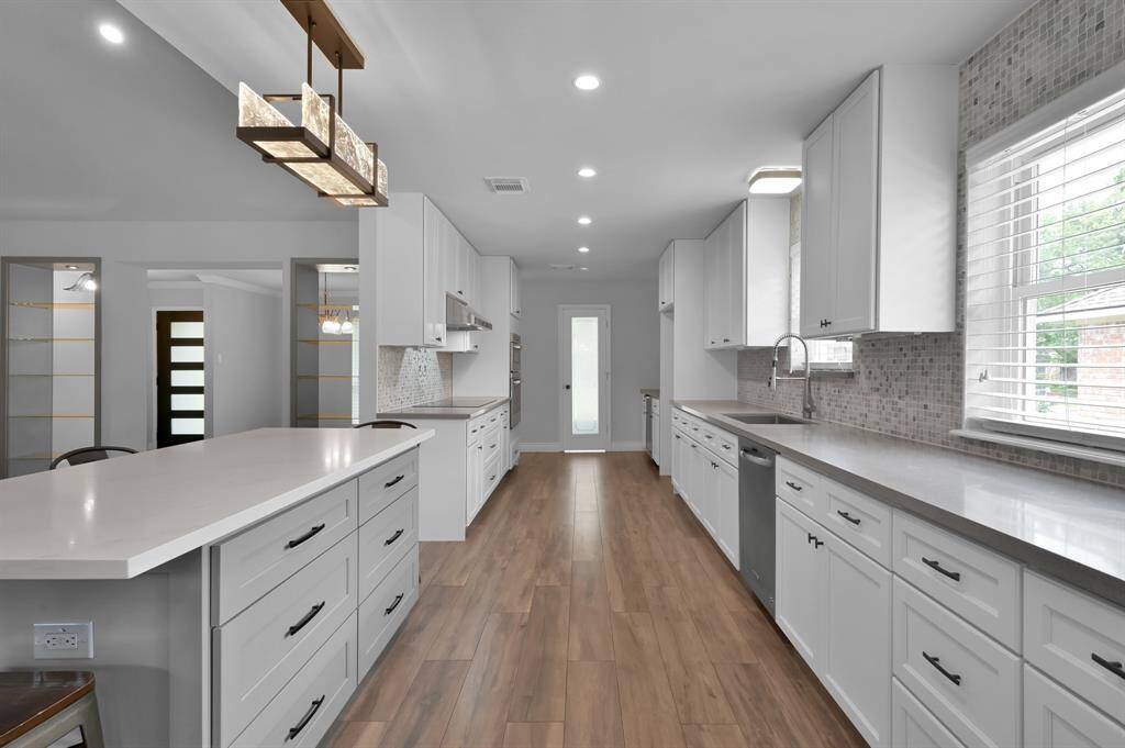 This chef-worthy kitchen features quartz countertops, soft-close cabinets, custom island, under-cabinet and inner cabinet lighting.