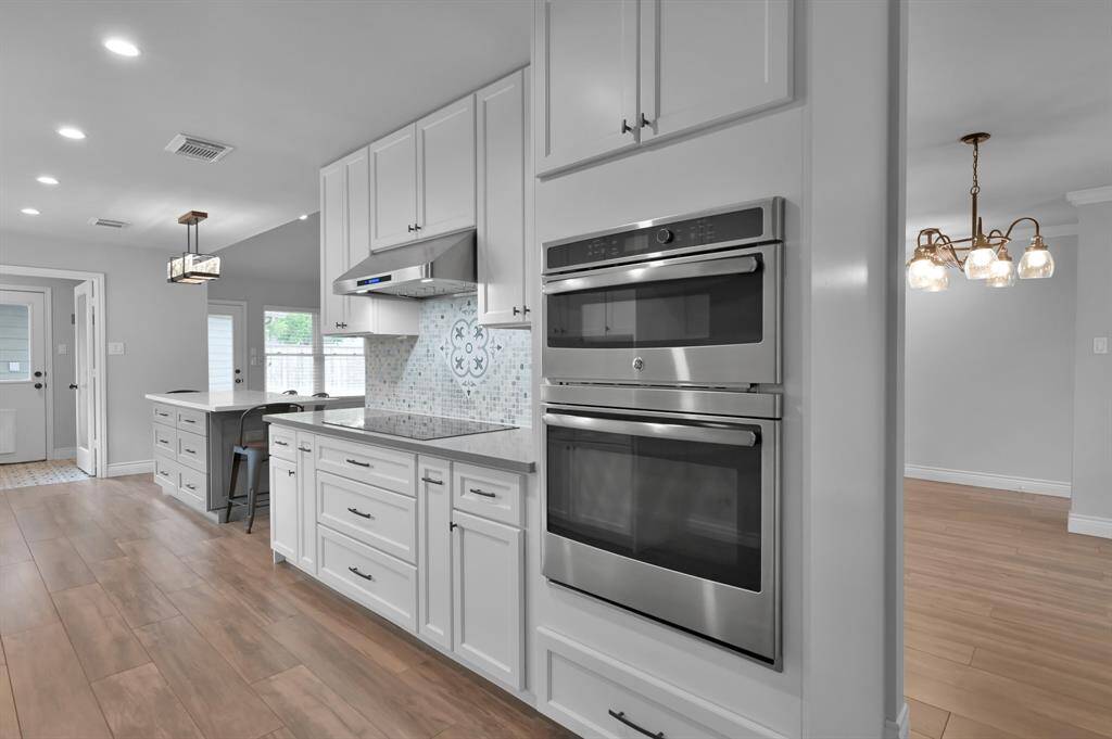 Sleek stainless appliances include a 36" Bosch induction cooktop, built in microwave and vent hood.