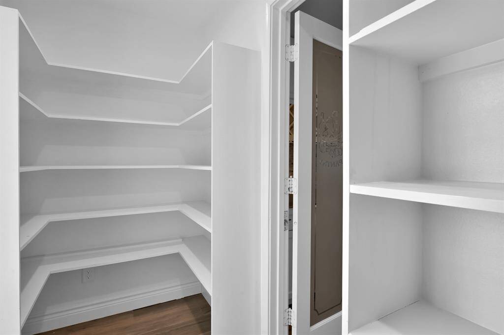 Incredible walk-in pantry offers two-sides of built-in shelving and designer glass door adds charm!