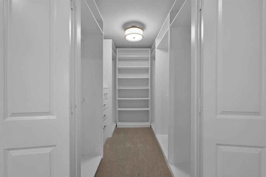 Custom California-styled closet offers built-in shelving, drawers and plenty of hanging space.