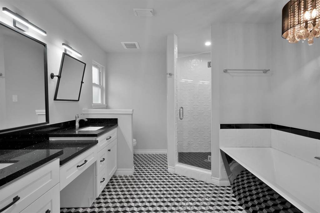 Sleek, contemporary bath features a soaking tub, separate shower and dual vanities with adjustable mirrors.