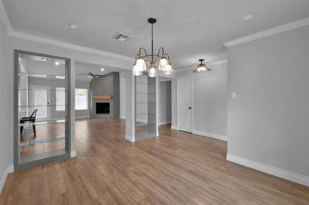Custom curio shelving separates the living and dining areas and wood-look tile flooring adds warmth throughout.