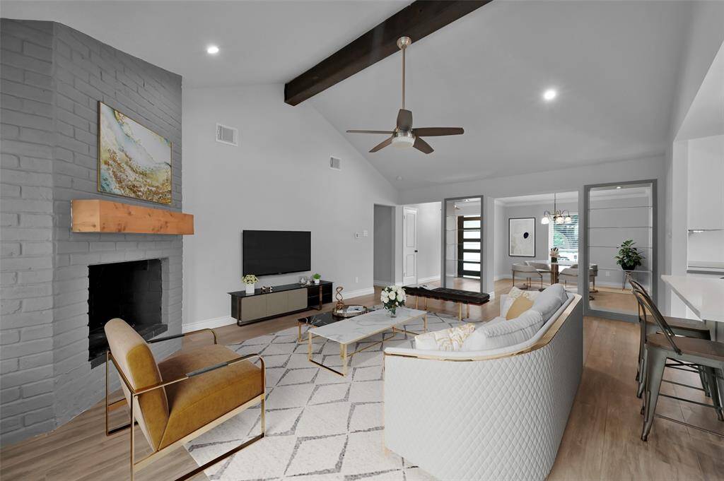 Vaulted family room with custom beam, painted brick wood-burning fireplace and recessed lighting. *photo is virtually staged.