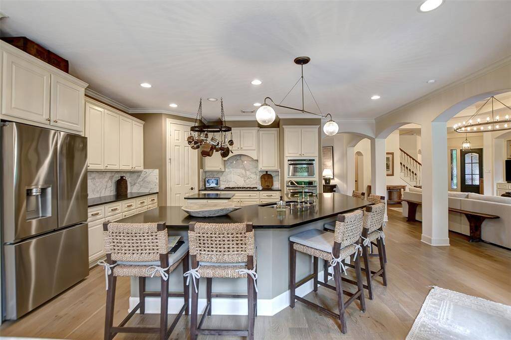 Luxurious remodeled kitchen featuring solid Calacatta marble backsplash, granite countertops, and sleek stainless steel appliances.