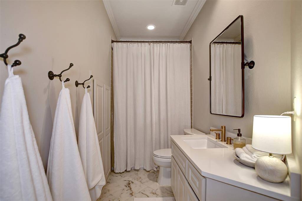 Elegant secondary bathroom featuring Calacatta marble floors, sleek Silestone countertops, and stylish subway tile shower, all enhanced by modern fixtures.
