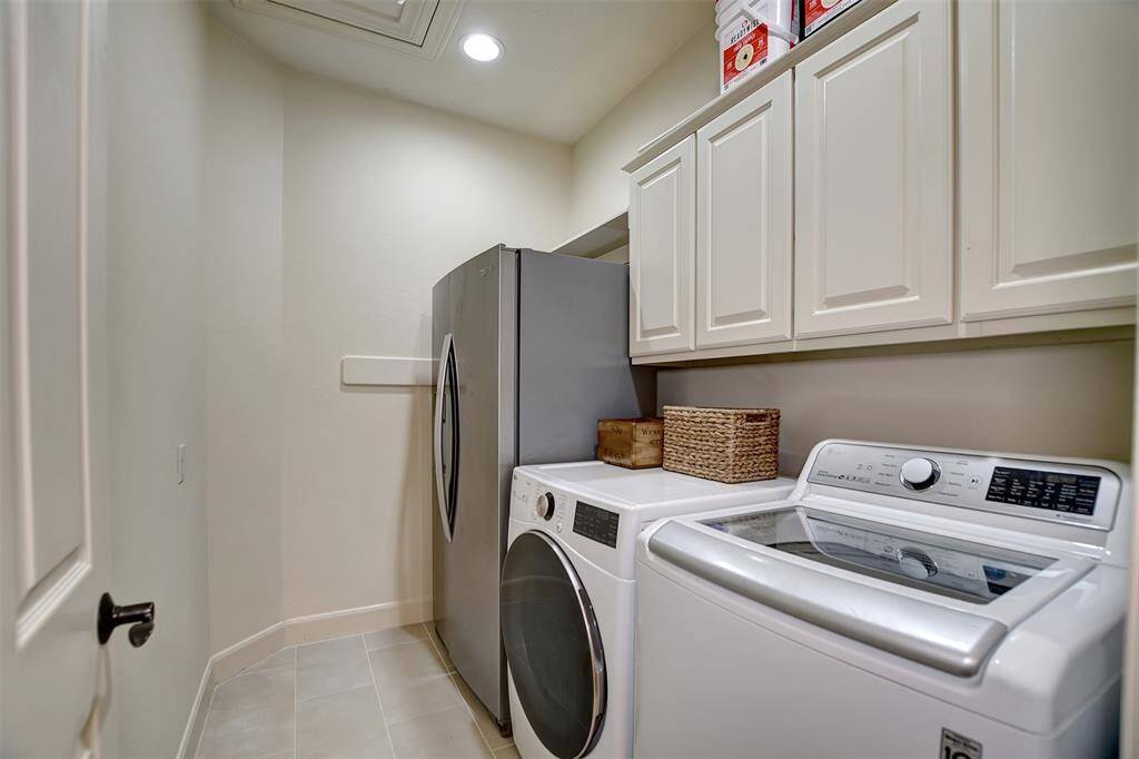 Spacious laundry room with built-in cabinets and space for a refrigerator.