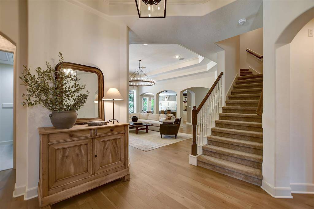 This cozy staircase leading upstairs to a spacious room and half bathroom. The open-concept living area has elegant archways, creating a spacious and welcoming atmosphere.