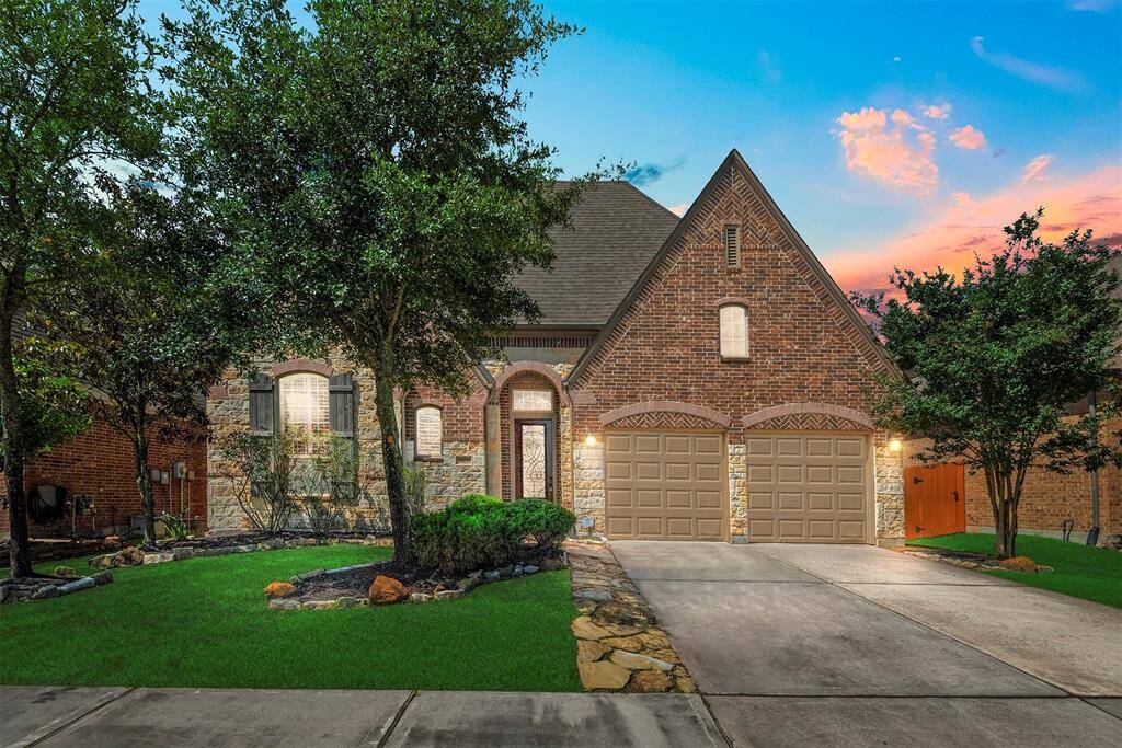 Gorgeous brick and stone elevation with mature trees and landscaping