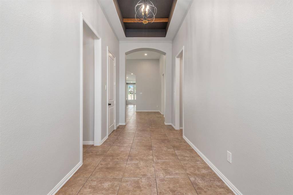 Grand entrance with 13-foot custom painted tray ceiling with wood beams and elegant chandelier.
