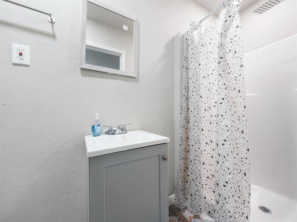 The connected en suite bath features a compact vanity and full shower. Clean lines and included accessories make the space as functional as it is inviting.