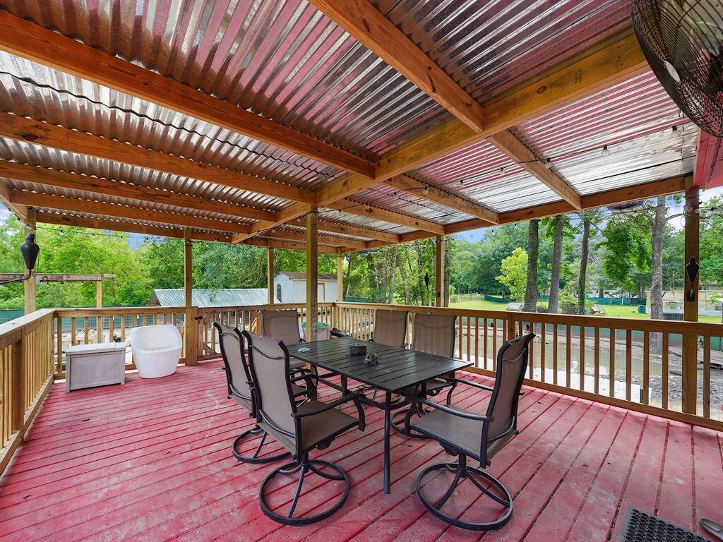 The expansive back porch is fully equipped for outdoor living with ample space for dining or lounging—furniture included—offering a perfect perch to overlook the grounds.