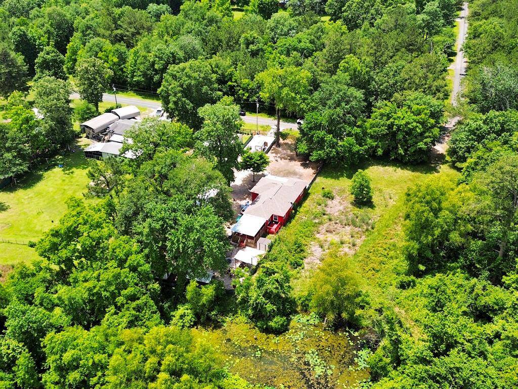 This broad aerial perspective shows the property's footprint, nestled among trees but easily accessible—a turnkey haven that doesn’t sacrifice convenience.