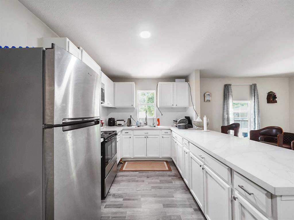 The kitchen features extensive cabinetry above and below, a gas cooktop and oven, and plenty of counter space for meal prep and entertaining - all ready for immediate use.