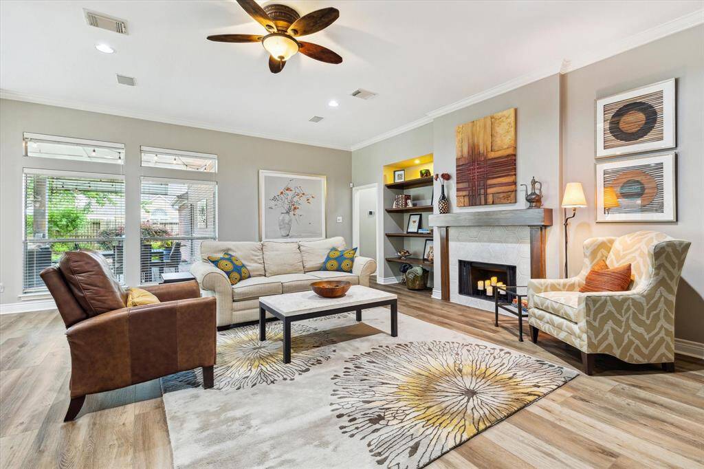 Your living room is very spacious and it's SO easy to arrange furniture with this design. You have some stained bookshelves and a matching wooden mantle flanking the fireplace. There's a pretty surround and it feels very homey.