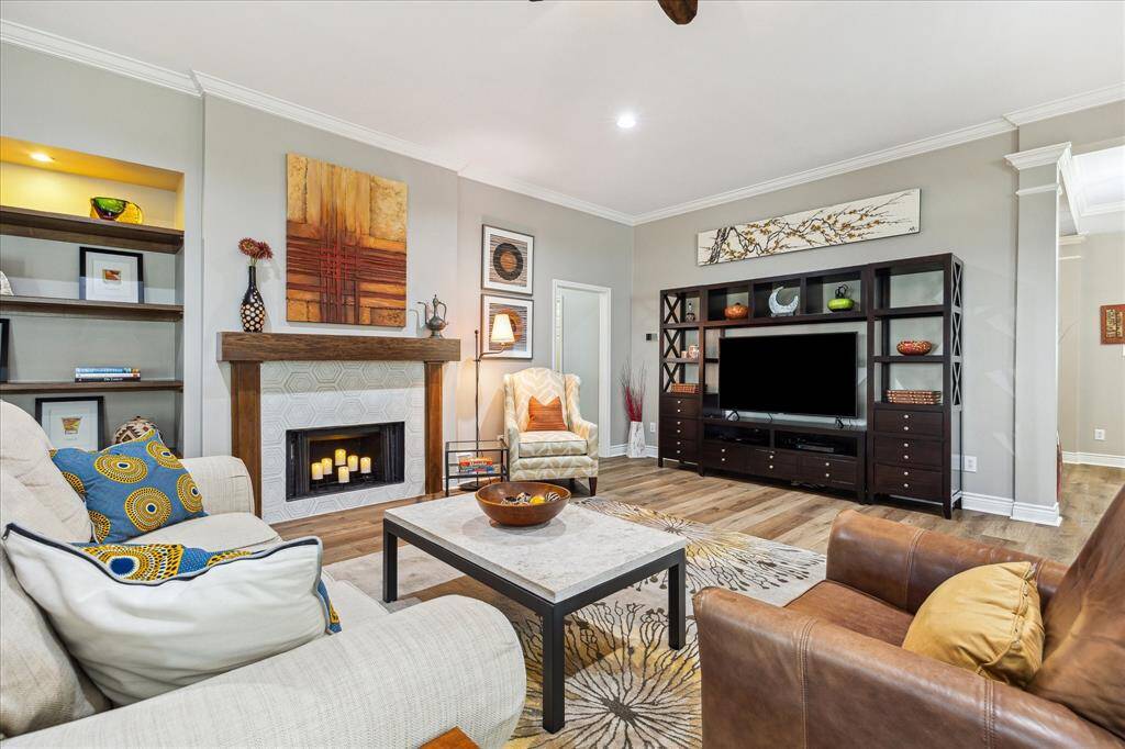 We are looking toward the front of the house. The piece that holds the TV can stay if you wish. It fits the space perfectly. The laundry room, a full bath, a hall closet, and the front bedroom are accessed through the opening behind the light-colored chair, as well as the middle room that connects with the 3rd secondary bedroom.