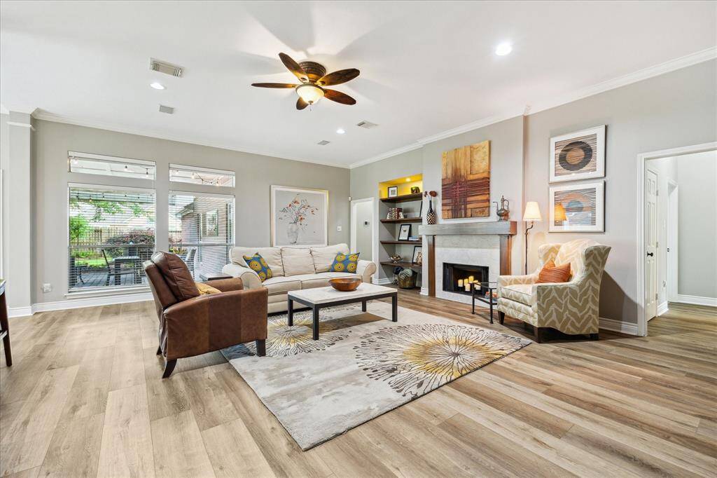 You can get a peek at the back patio through the windows. The primary suite is beyond the bookcases, as well as another bedroom. The front and middle bedrooms are accessible through the hallway to the right.