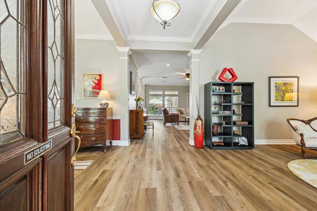 This is the view as you enter the home. You will love the soaring ceilings and open plan. The luxury vinyl plank floors are very tasteful and taller baseboards were added. You also have crown moulding in many areas.