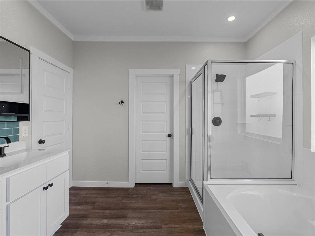 Primary bath features double sinks, soaking tub, walk-in shower and a walk-in closet