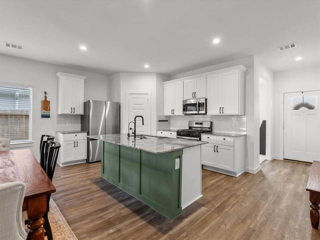 Chef's eat-in island kitchen features 42" shaker style cabinets, under mount sink and stainless steel appliances