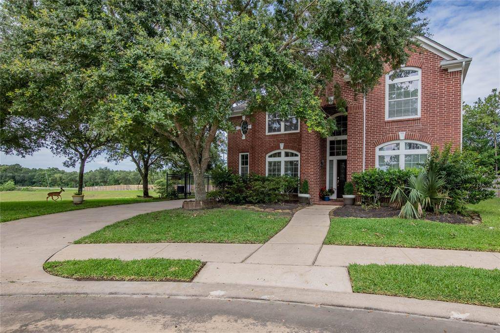 Charming brick home with lush landscaping and a welcoming entrance, set on a spacious lot with scenic views.