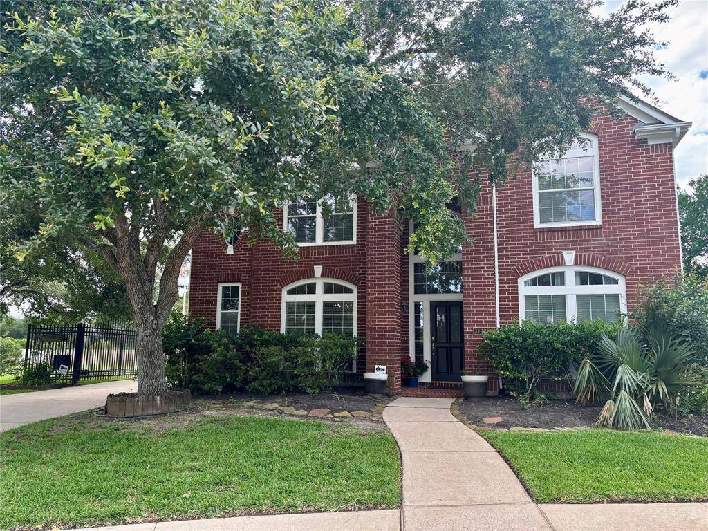 Charming brick home offering ultimate privacy with only one neighbor, serene nature views, a remote-controlled iron gate, and the shade of mature trees.