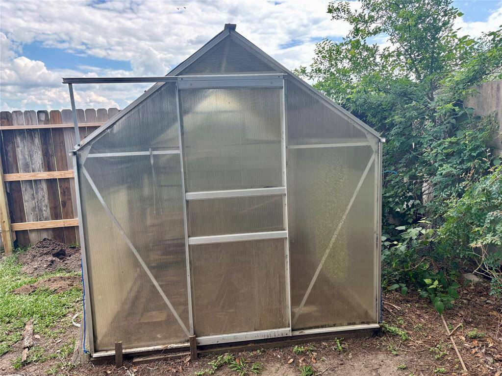 There is a greenhouse behind the garage.
