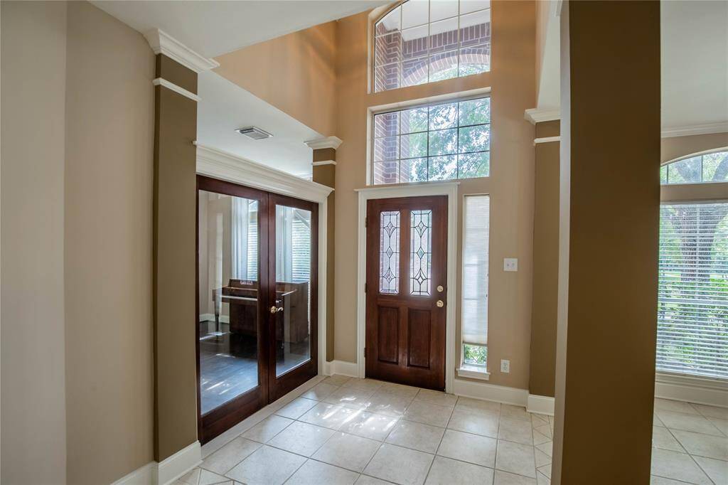 Experience the elegance of this inviting entryway, featuring high ceilings, abundant natural light, and beautiful tile flooring.
