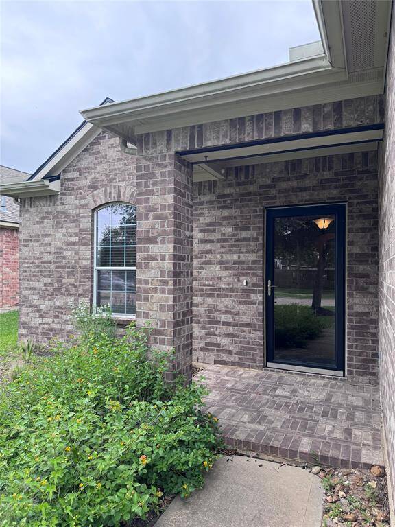 Wide Front Porch area with glass storm door in front of solid wood/iron door