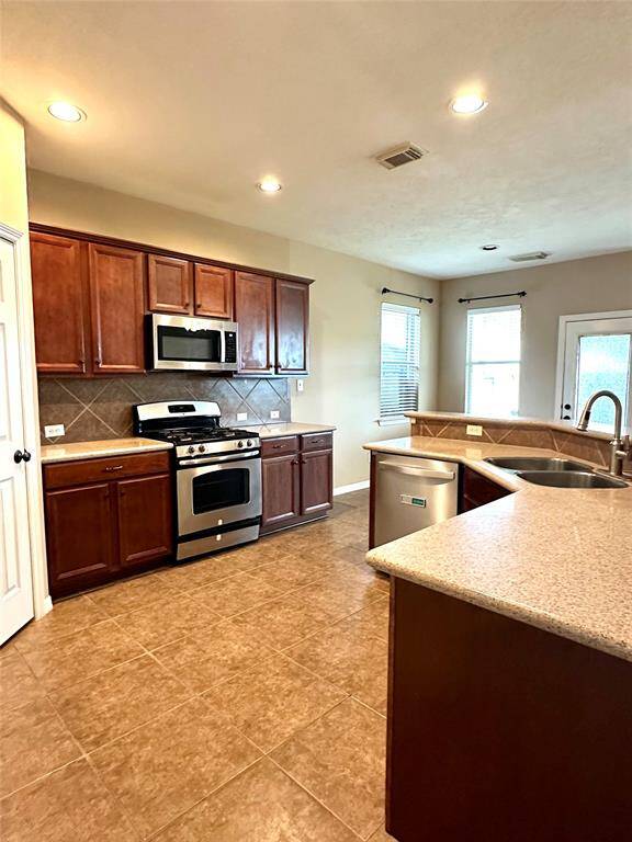 Open kitchen area with stainless appliances allows for easy flow of traffic, perfect for those busy mornings!