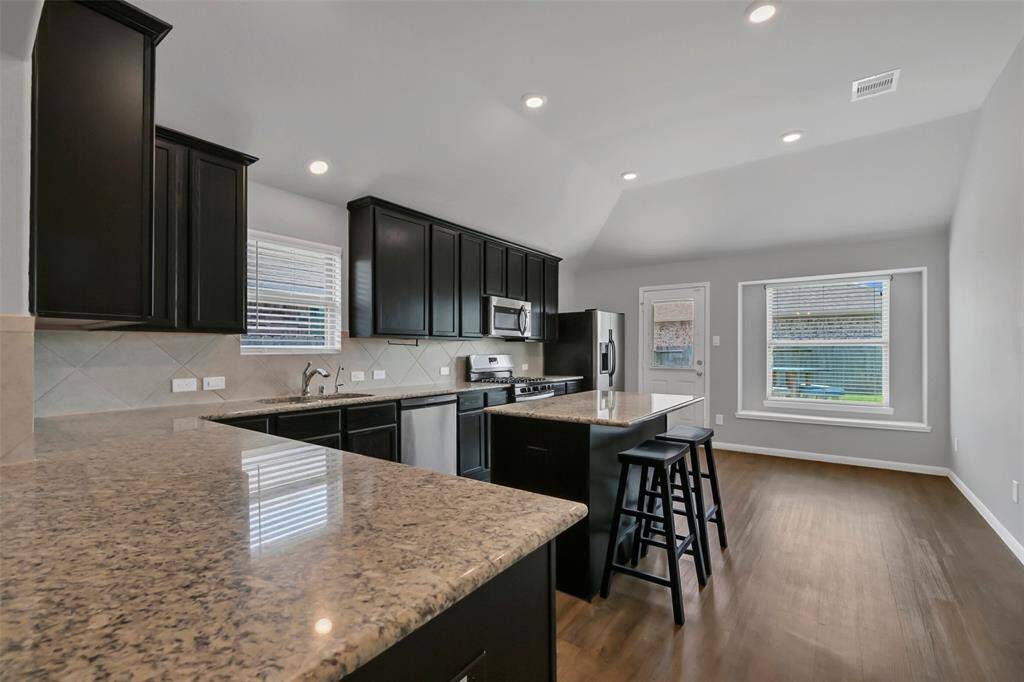 Rows of dark-stained cabinetry provide ample storage in this Chef's kitchen.