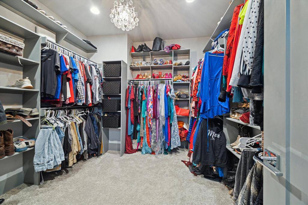 Huge walk-in closet with custom built-ins and chandelier.