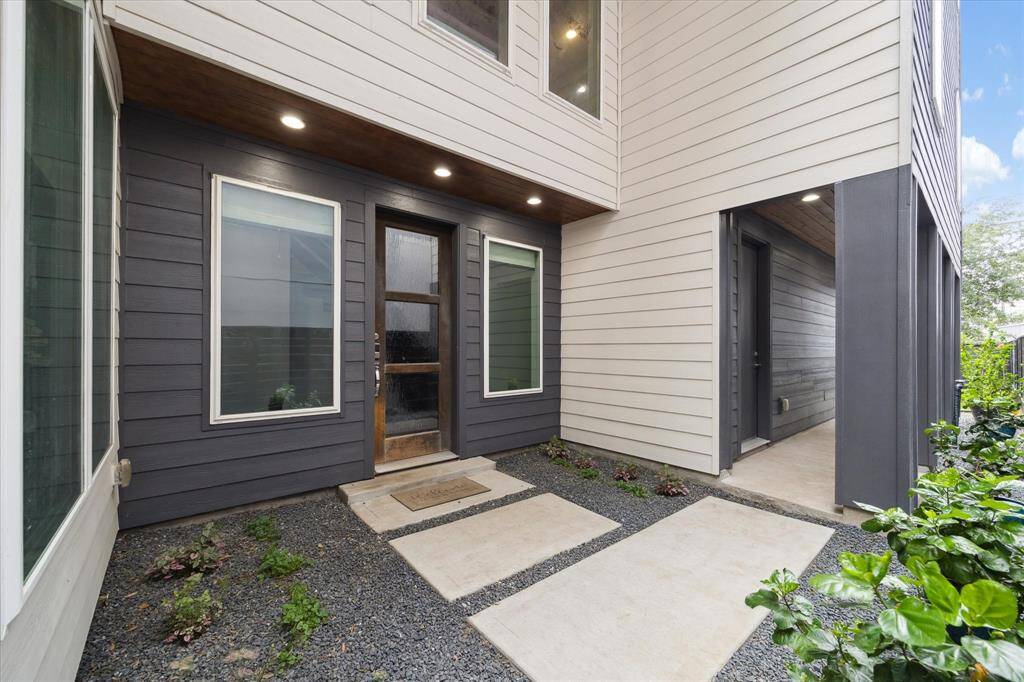 The walkway up to the front door is surrounded by lush landscaping.