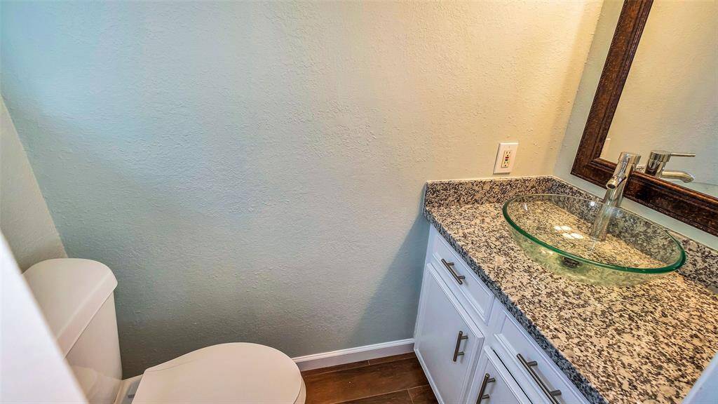 Powder Room with Granite counter vanity and bowl sink.