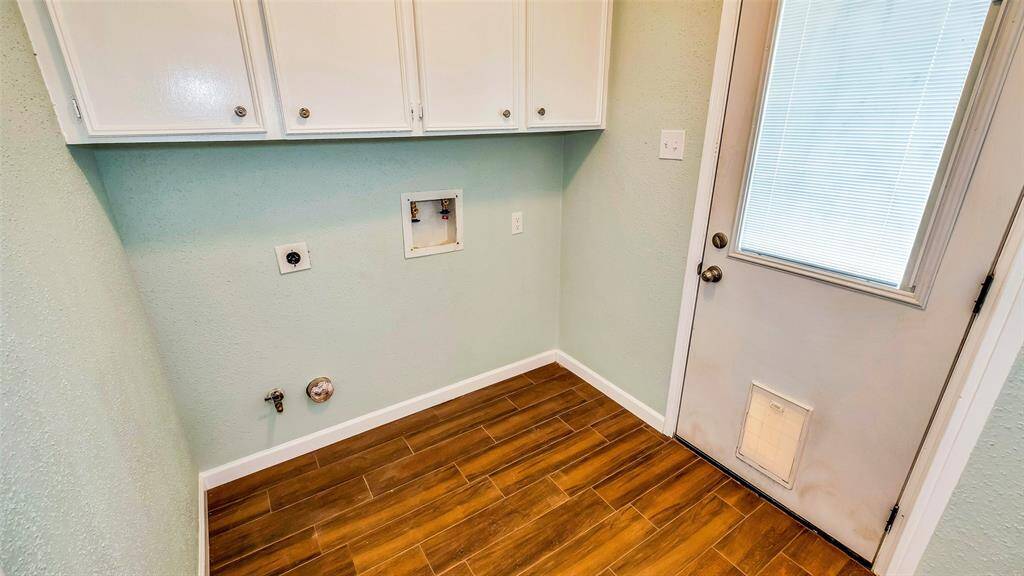 Washer room with lots of cabinets.