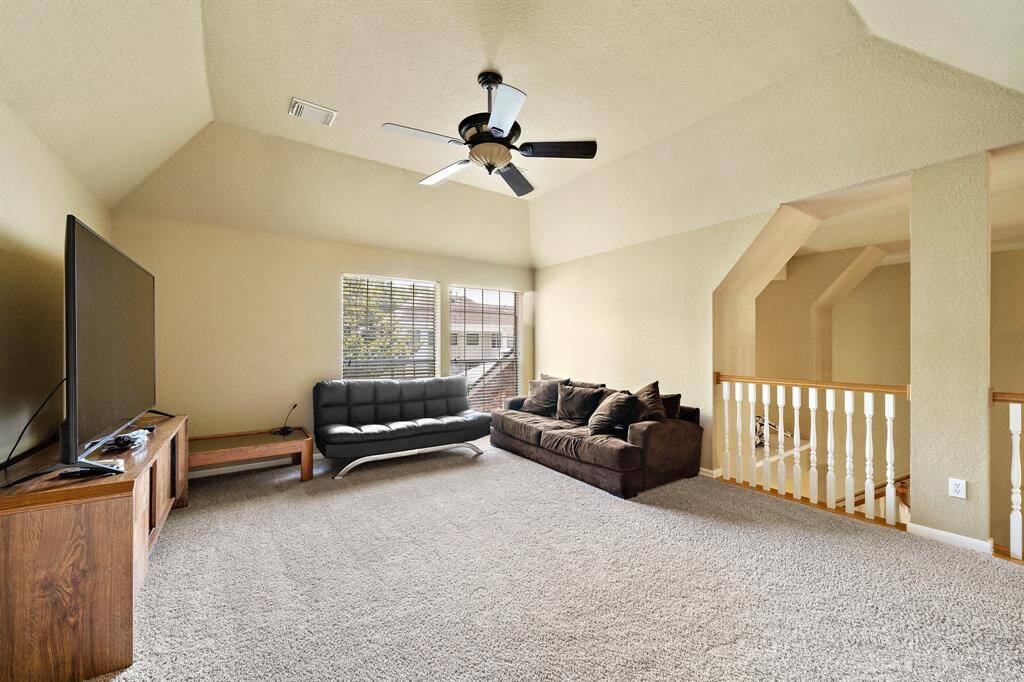 Generously sized game room with a vaulted ceiling.