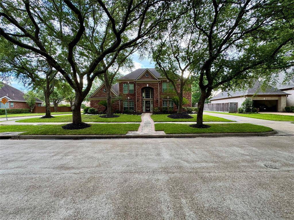 A sizable corner lot enhanced by the natural canopy of lush, stately trees.