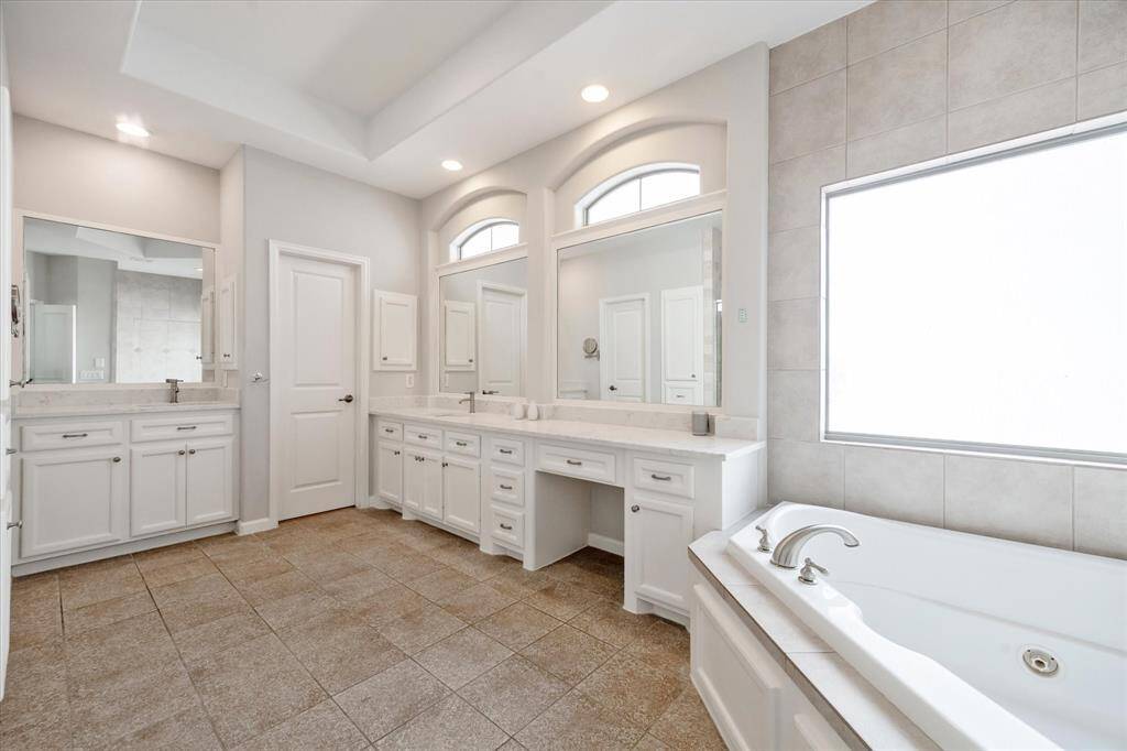 Luxurious ensuite bath also features a corner jetted tub to soak away the stress of the day