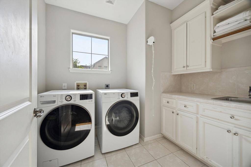 Convenient second floor utlilty room features abundant storage and sink;dryer is included