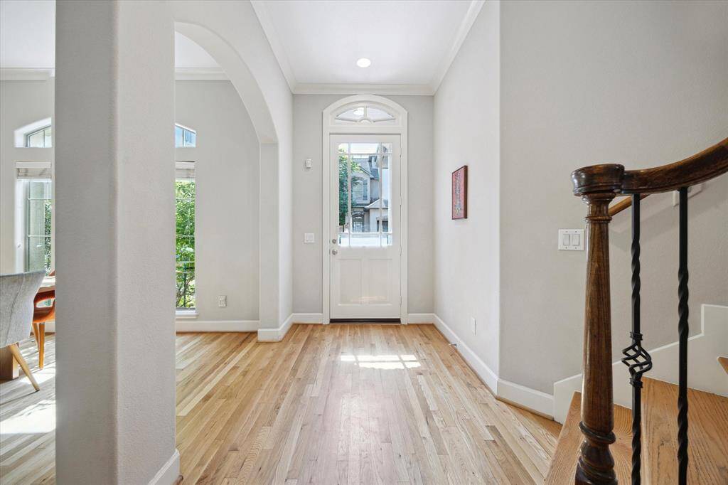 Exceptional foyer with beautiful hardwoods and wrought iron staircase