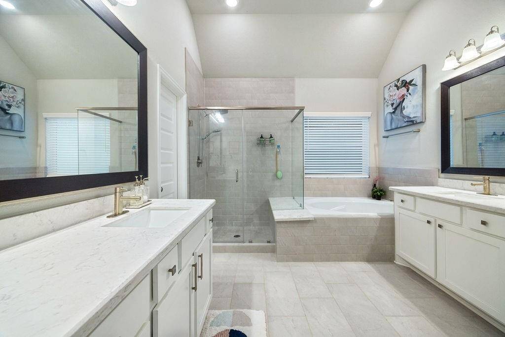 Ensuite primary bathroom with double vanity, separate shower and soaking tub