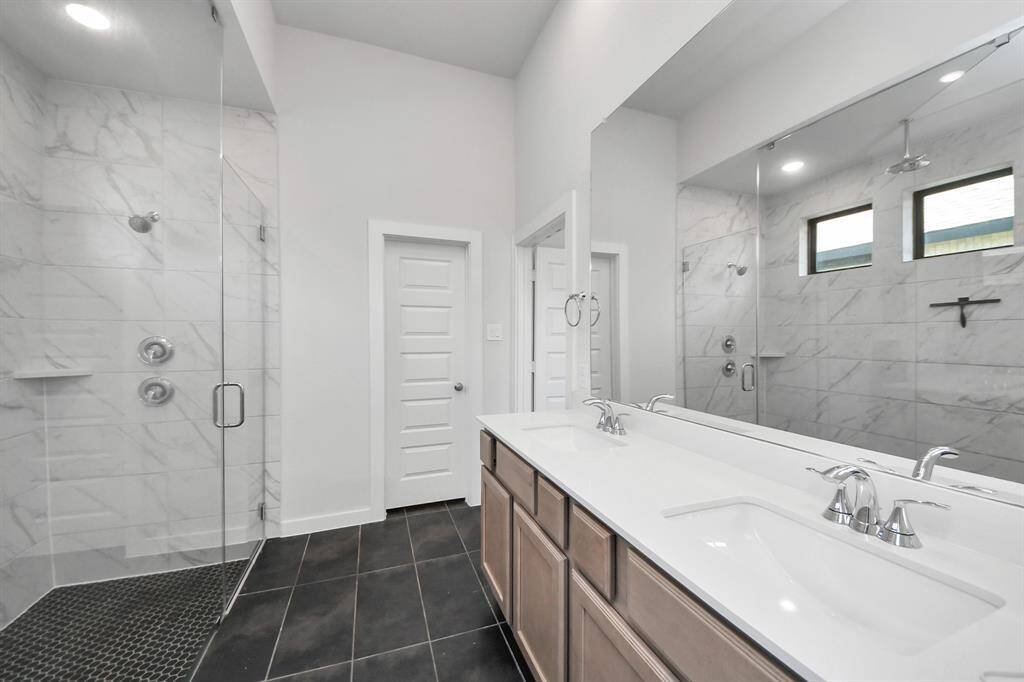 Black Tile and Blonde Wood Cabinets in Primary Bath.
