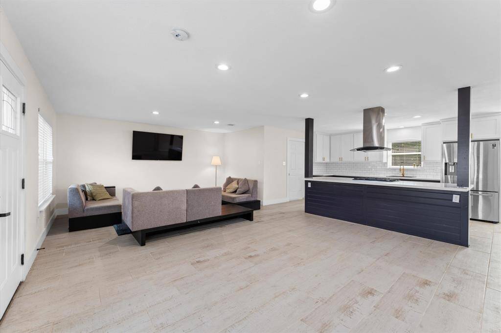 Bright and open living area with wood-look tile flooring and plenty of natural light.