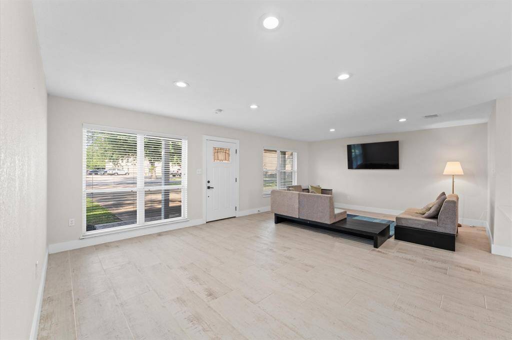 Bright and open living area with wood-look tile flooring and plenty of natural light.