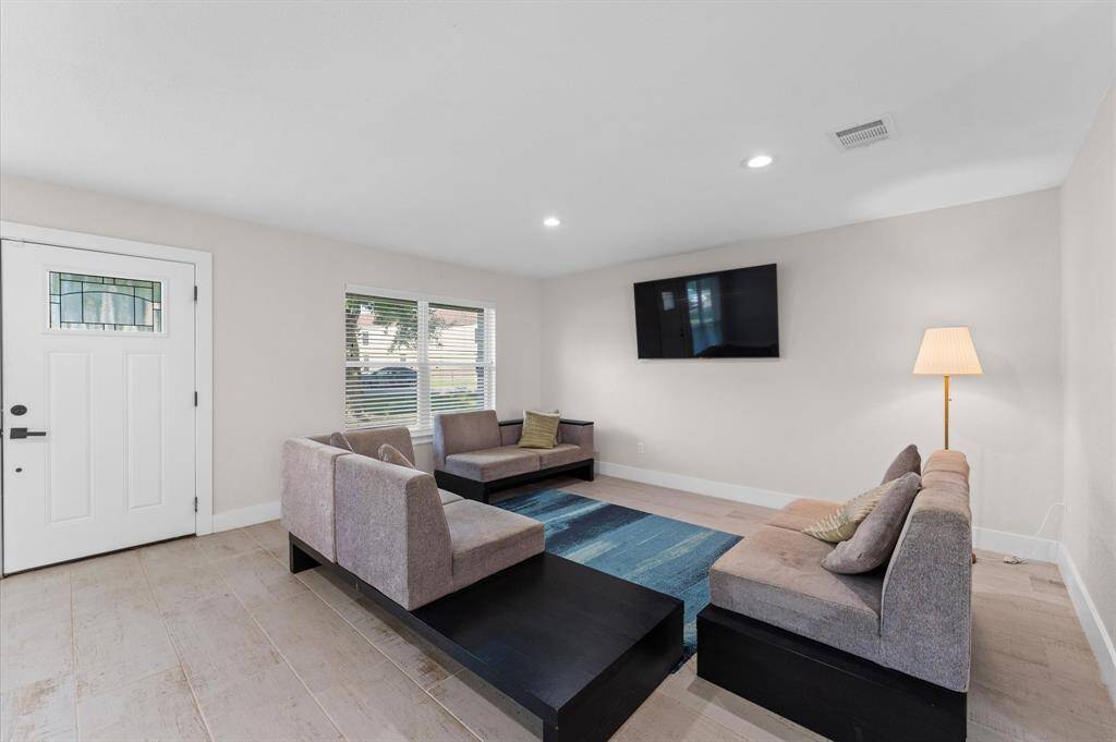 Bright and open living area with wood-look tile flooring and plenty of natural light.