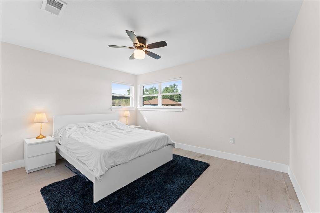 Spacious and updated second bedroom with wood-look tile and ample closet space.