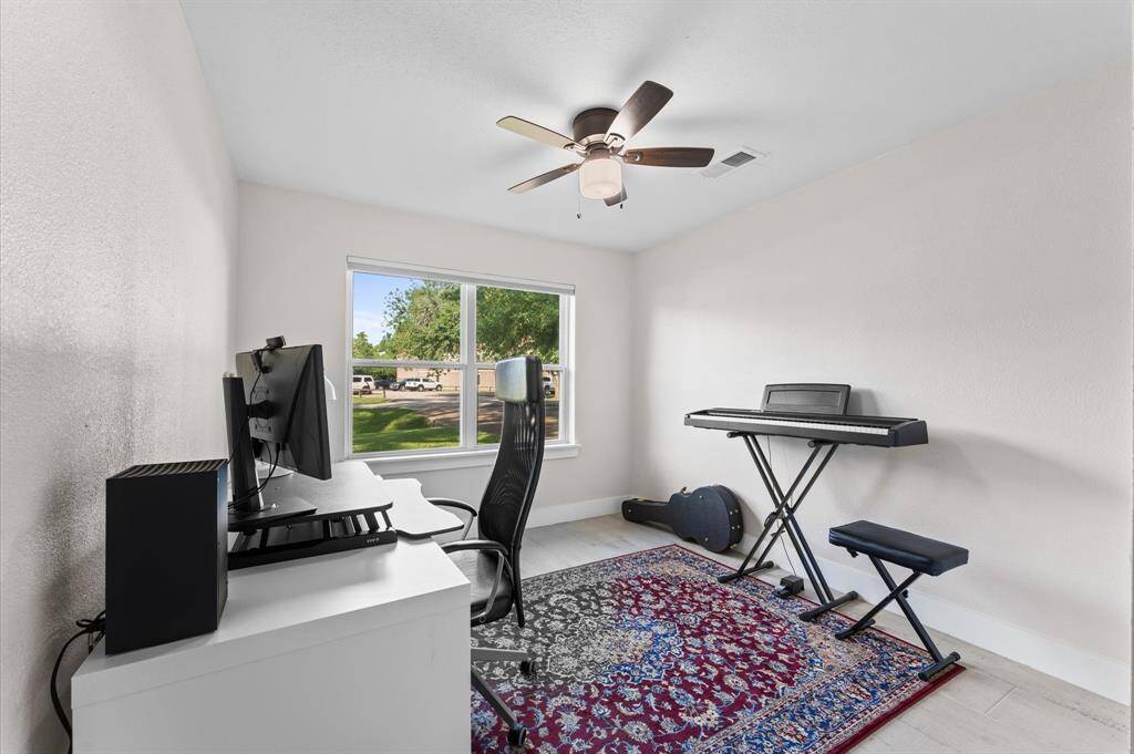 Spacious and updated third bedroom with wood-look tile and ample closet space.