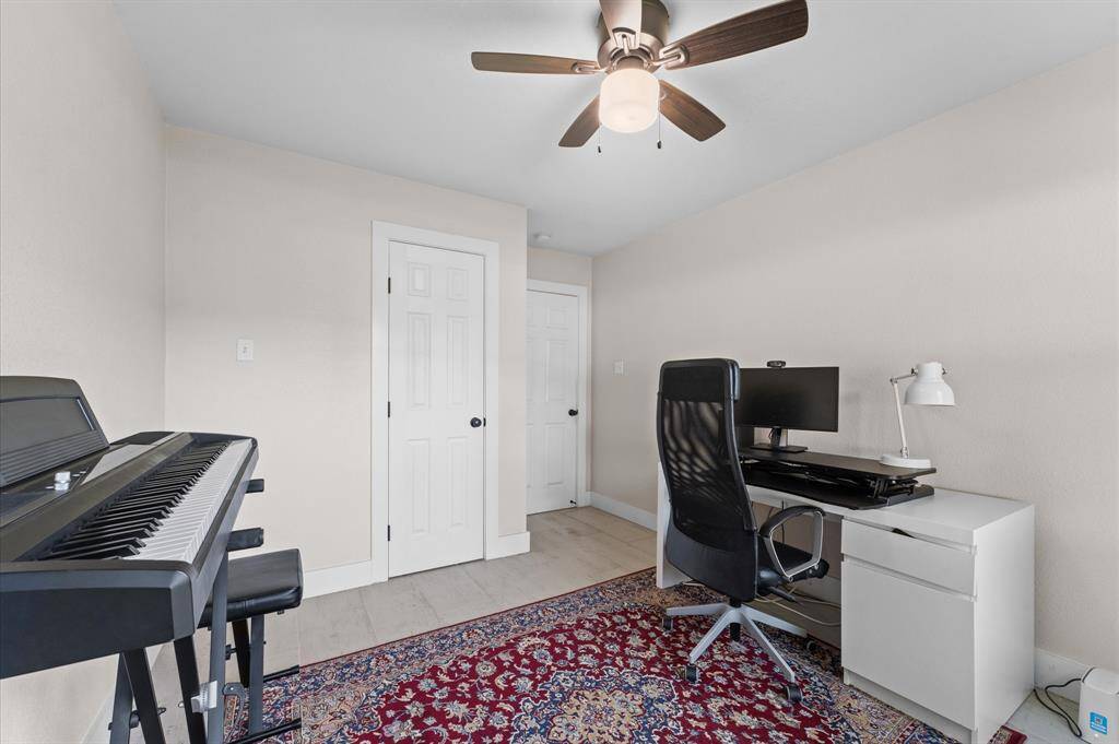 Spacious and updated third bedroom with wood-look tile and ample closet space.