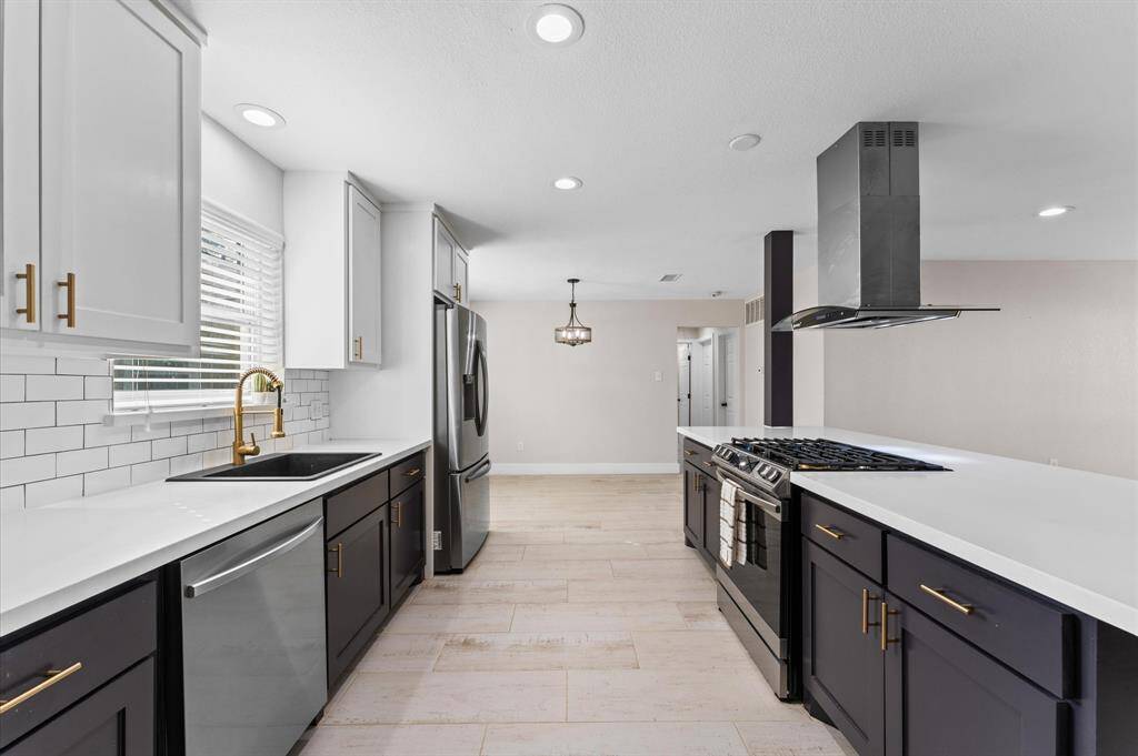 Gorgeous modern kitchen featuring quartz countertops, subway tile backsplash, and stainless steel appliances.