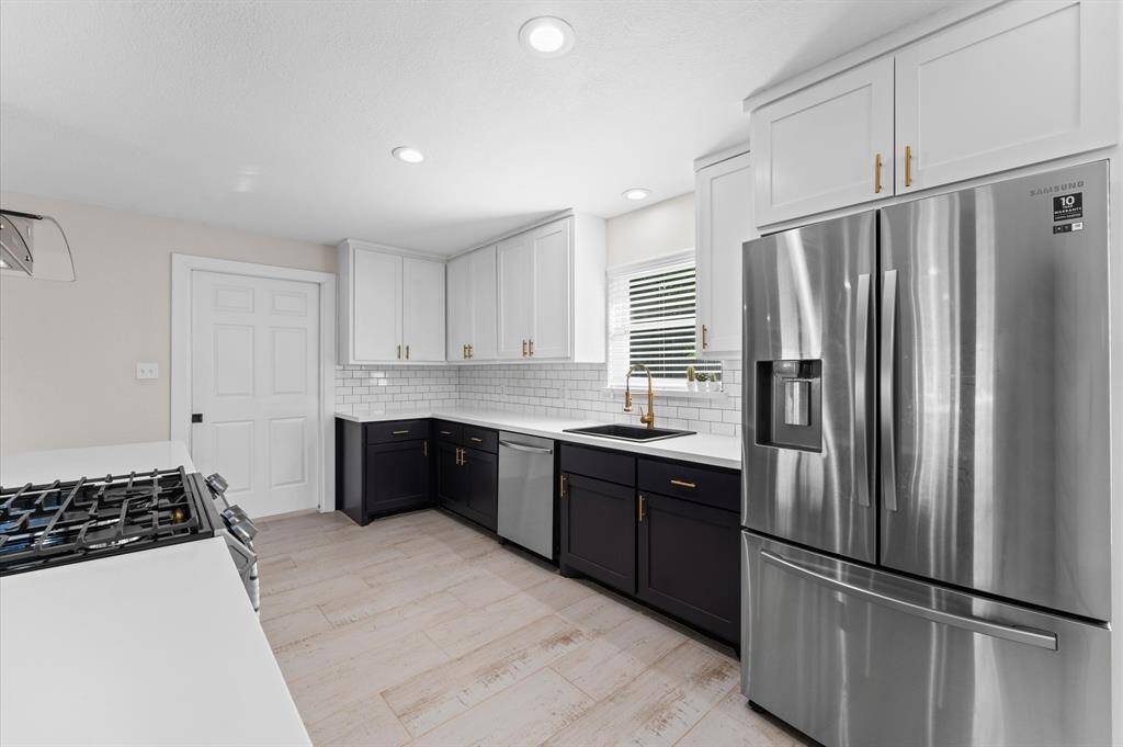 Gorgeous modern kitchen featuring quartz countertops, subway tile backsplash, and stainless steel appliances.