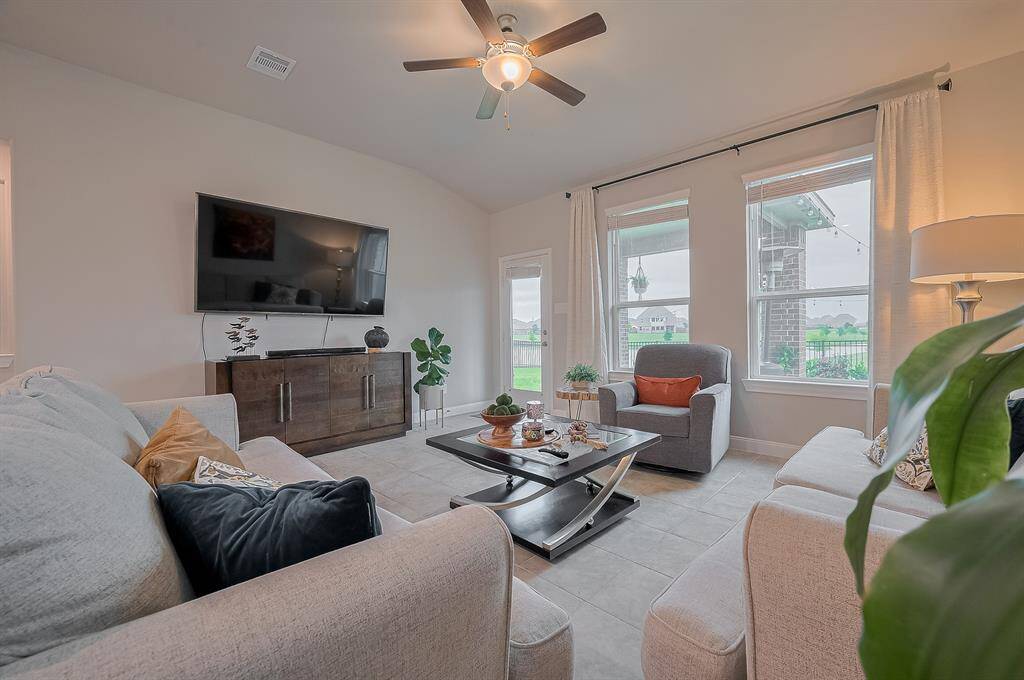 Bright and inviting living room with large windows, perfect for relaxation and entertainment.
